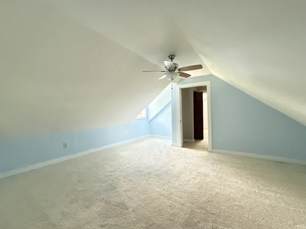 an empty room with a ceiling fan and window
