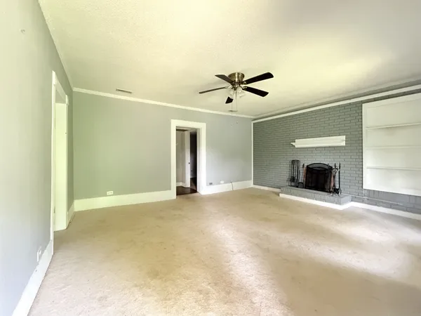 a view of an empty room with a fireplace and a window
