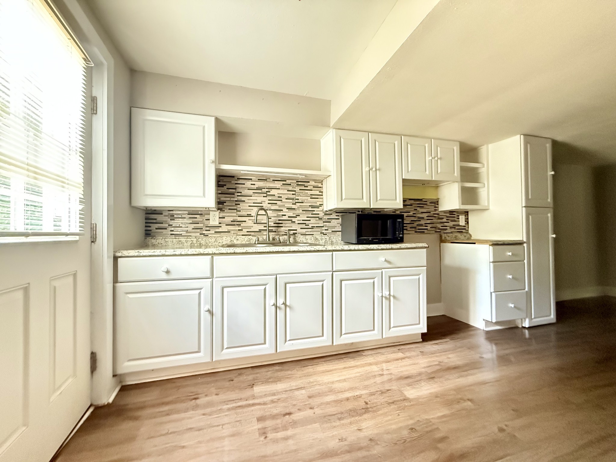 2844 Jarman Hollow Road Palmyra, TN 37142 - Photo 5 of 32 a kitchen with stainless steel appliances white cabinets and wooden floors