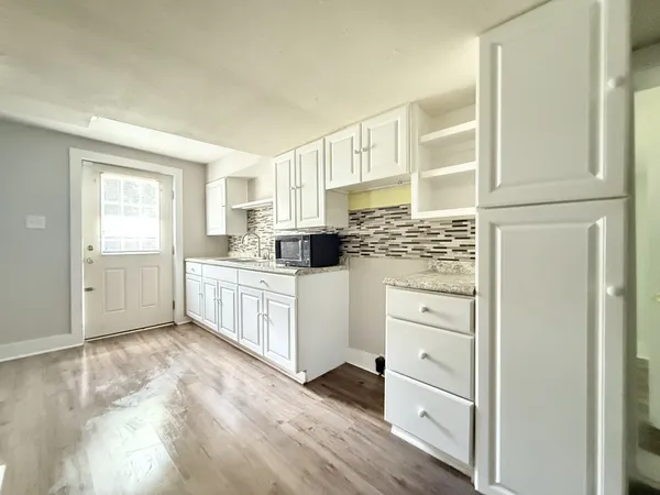a kitchen with white cabinets and white appliances