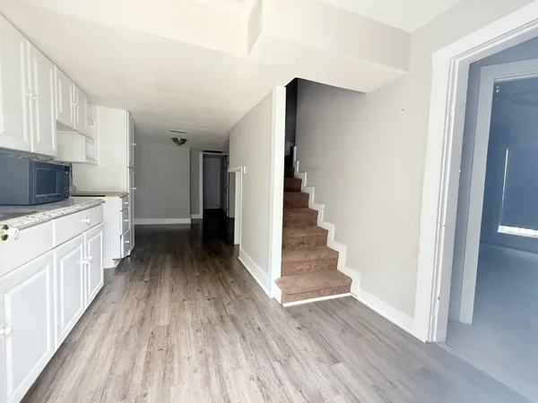 a view of a kitchen with wooden floor and electronic appliances