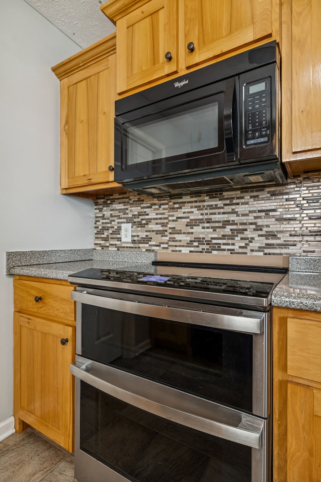 136 Thacker Drive Portland, TN 37148 - Photo 12 of 39 a kitchen with granite countertop cabinets stainless steel appliances and wooden floor