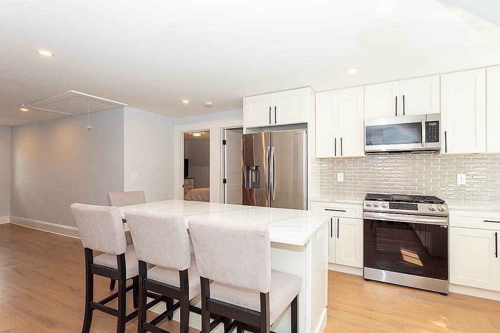 a kitchen with a table chairs refrigerator and microwave