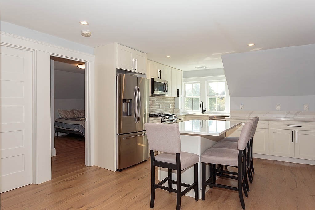 79 Robert Street, Unit 3 Boston, MA 02131 - Photo 4 of 20 a kitchen with a table and refrigerator