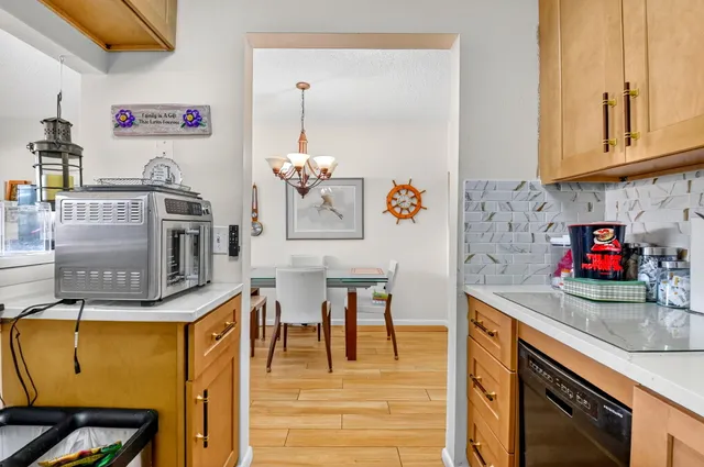 a view of a dining hall with furniture and a kitchen area