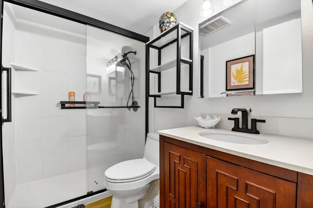 a bathroom with a granite countertop sink toilet and shower