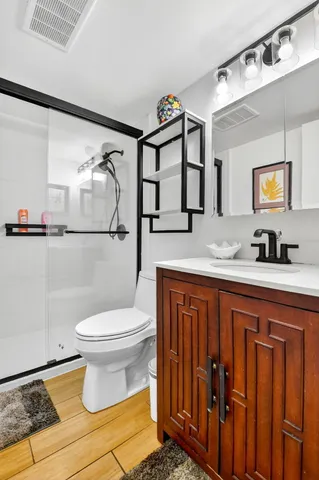 a bathroom with a granite countertop sink mirror vanity and toilet