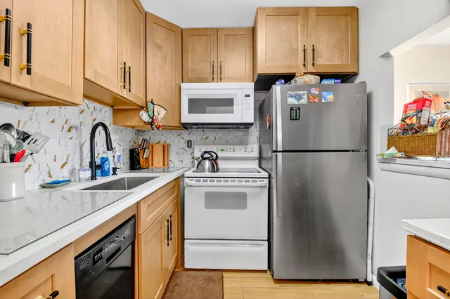 a kitchen with stainless steel appliances granite countertop a refrigerator sink and cabinets