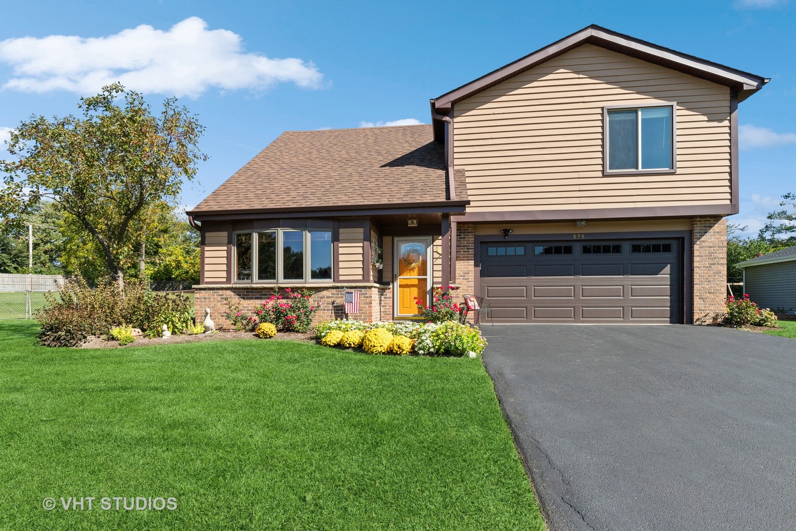 a front view of a house with a garden and plants
