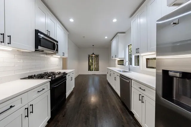 a large kitchen with stainless steel appliances granite countertop a stove and a sink