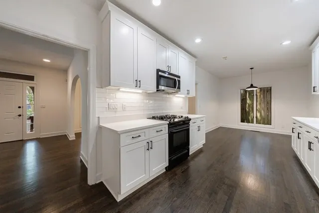 a kitchen with stainless steel appliances granite countertop a stove a sink and a refrigerator