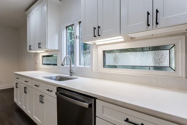 a kitchen with granite countertop a sink and cabinets
