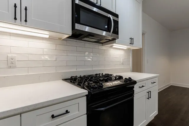 a kitchen with stainless steel appliances a sink dishwasher stove and oven with wooden floor