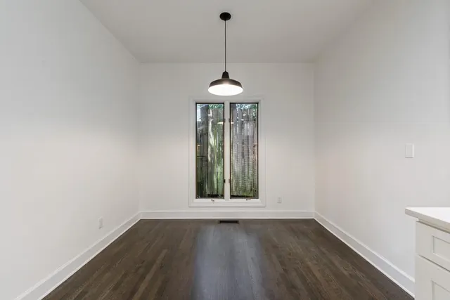 a kitchen with wooden floors and white cabinets