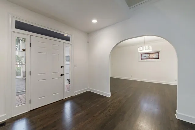 an empty room with wooden floor and white walls
