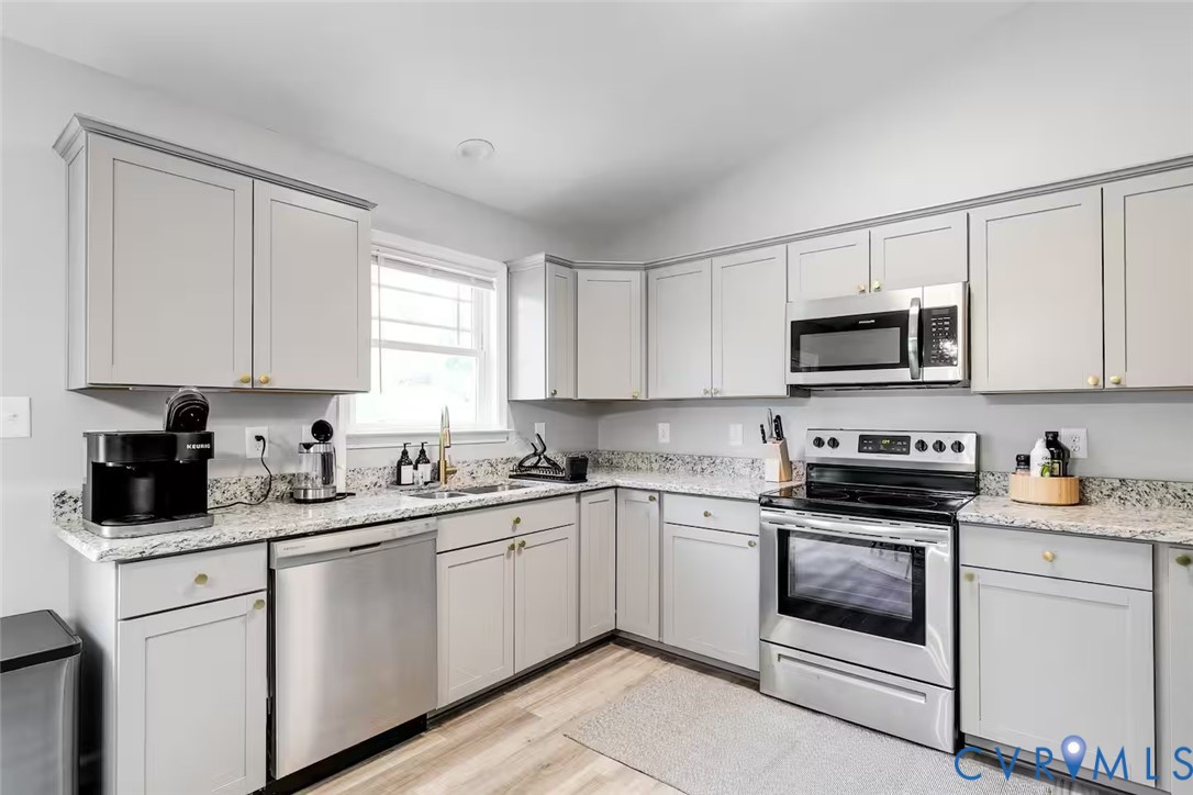 711 Jackson Street Colonial Beach, VA 22443 - Photo 17 of 41 a kitchen with white cabinets appliances a sink and a window