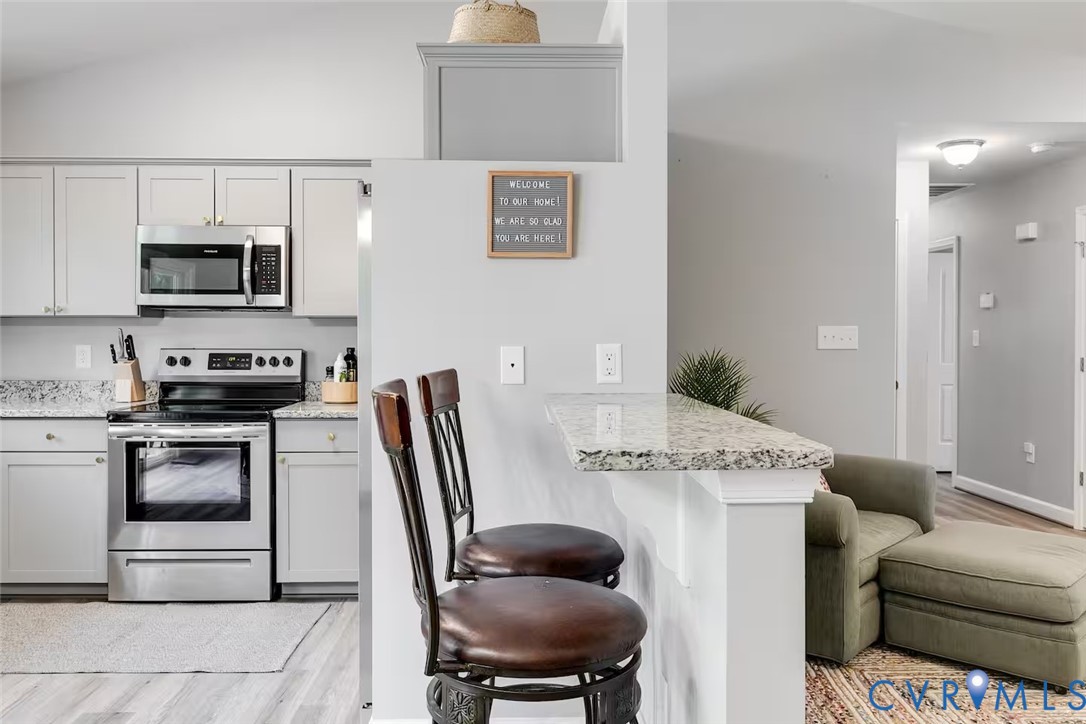 711 Jackson Street Colonial Beach, VA 22443 - Photo 21 of 41 a kitchen with stainless steel appliances granite countertop a stove microwave and refrigerator