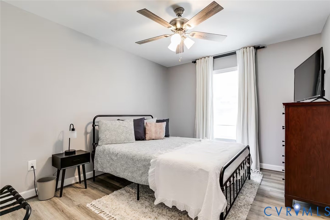 711 Jackson Street Colonial Beach, VA 22443 - Photo 27 of 41 a spacious bedroom with a bed and a chandelier