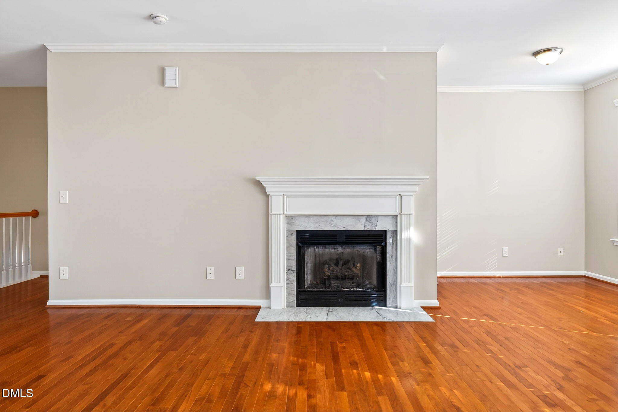 4523 Pale Moss Drive Raleigh, NC 27606 - Photo 9 of 42 a view of an empty room with wooden floor a fireplace and a window