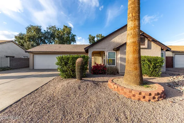 a view of a house with backyard and a tree