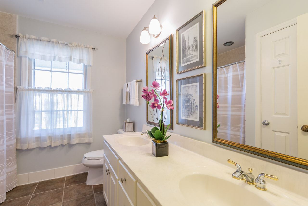 7616 Harps Mill Road Raleigh, NC 27615 - Photo 19 of 24 Tub/shower combination with tile surround and a vanity with double sinks. 2nd Floor Full Bath