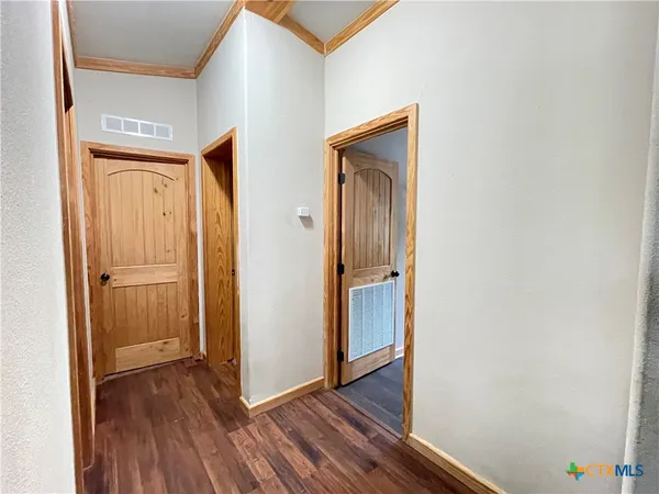 a view of a hallway with wooden floor