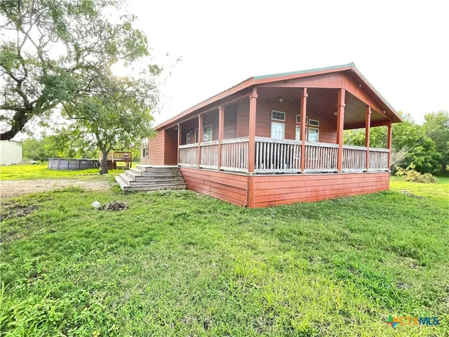 a view of a house with backyard and trees