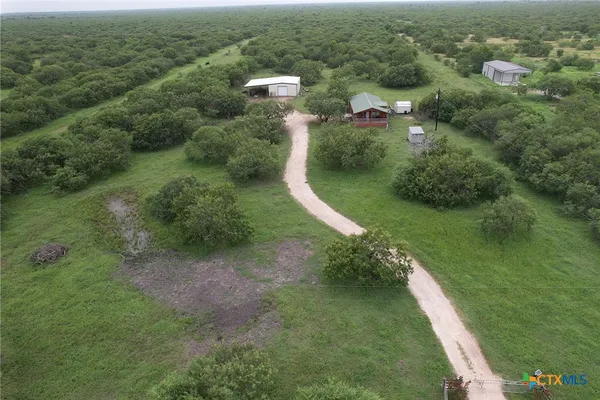 an aerial view of residential houses with outdoor space and trees
