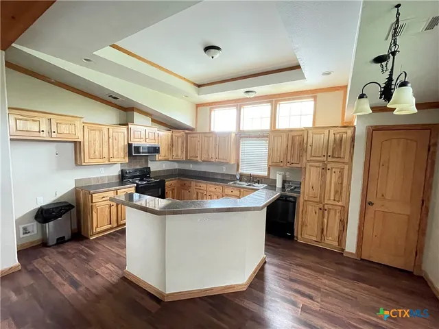 a kitchen that has a sink stainless steel appliances a counter space and wooden floor
