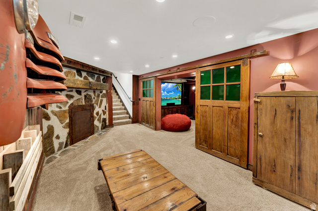 2983 East Ridgetop Road, Unit 27 Provo, UT 84604 - Photo 48 of 63 Recreation space featuring a stone accent wall with a wood beam mantel, carpeted flooring, and recessed lighting