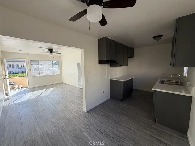 a view of a kitchen with a sink cabinet a kitchen a refrigerator and a flat screen tv