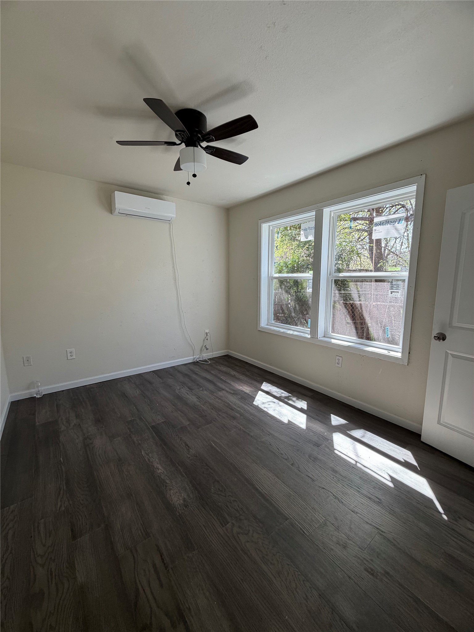 507 Swanee Drive, Unit B Austin, TX 78752 - Photo 6 of 8 a view of an empty room with wooden floor and a window