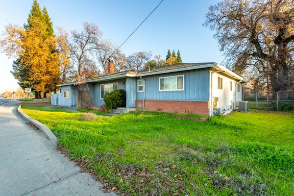 a view of a house with backyard and sitting area