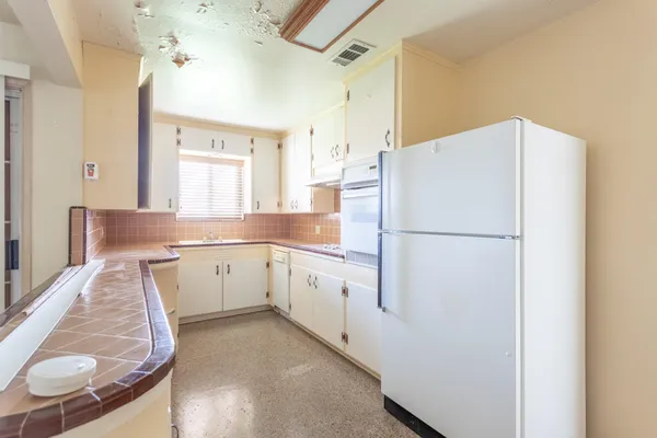 a white refrigerator freezer sitting inside of a kitchen