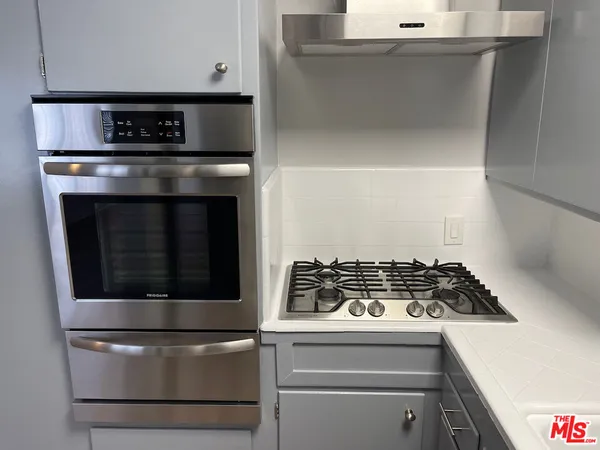 a kitchen with granite countertop white cabinets and stainless steel appliances