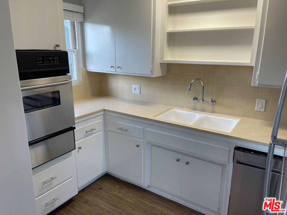 137 North Myrtle Avenue Monrovia, CA 91016 - Photo 18 of 41 a kitchen with granite countertop white cabinets and stainless steel appliances