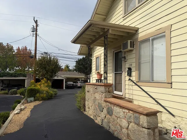a view of a house with backyard and sitting area