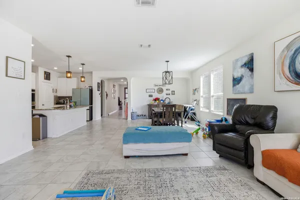 a living room with furniture and a dining table with kitchen view