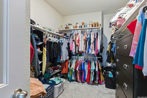 a view of walk in closet with clothes and shoes