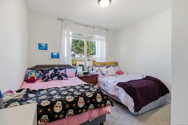 a bedroom with two beds and a window