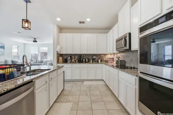 a large kitchen with stainless steel appliances granite countertop a stove a sink and a microwave