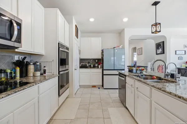 a kitchen with stainless steel appliances granite countertop a refrigerator and a sink