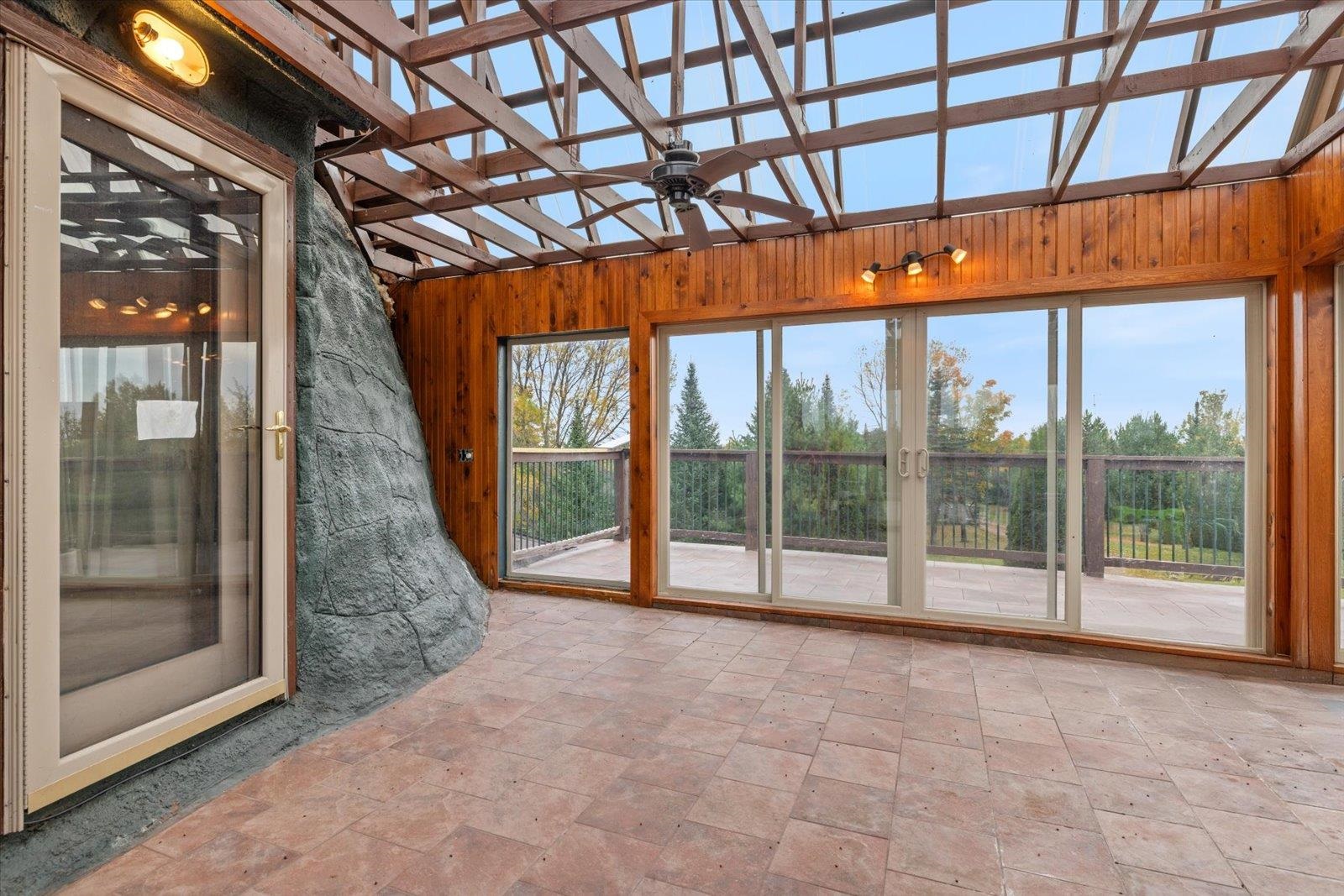 3581 County Line Road Sturgeon Lake, MN 55783 - Photo 15 of 85 Unfurnished sunroom with wood walls and stone finish floors