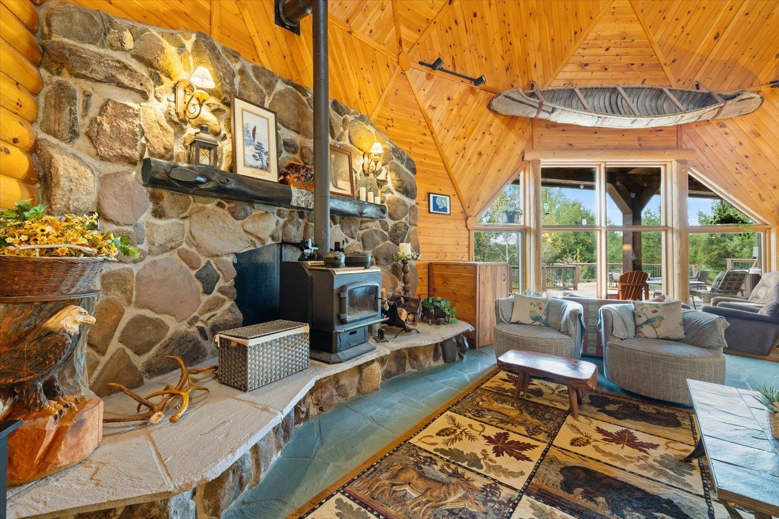 3581 County Line Road Sturgeon Lake, MN 55783 - Photo 33 of 85 Living room featuring a wood stove, wood ceiling, wooden walls, and high vaulted ceiling