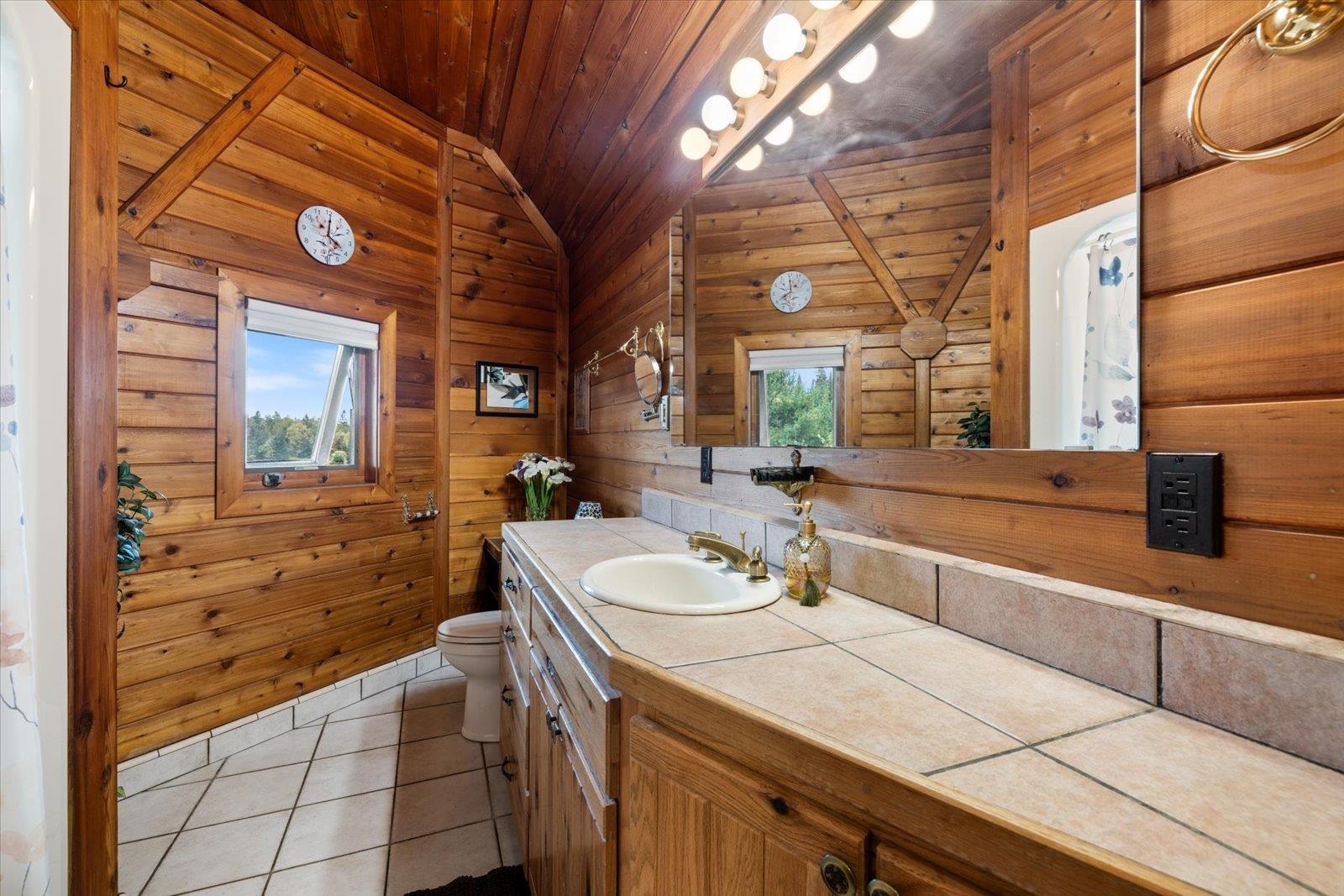 3581 County Line Road Sturgeon Lake, MN 55783 - Photo 55 of 85 Bathroom with light tile patterned flooring, vanity, wooden walls, wooden ceiling, and lofted ceiling