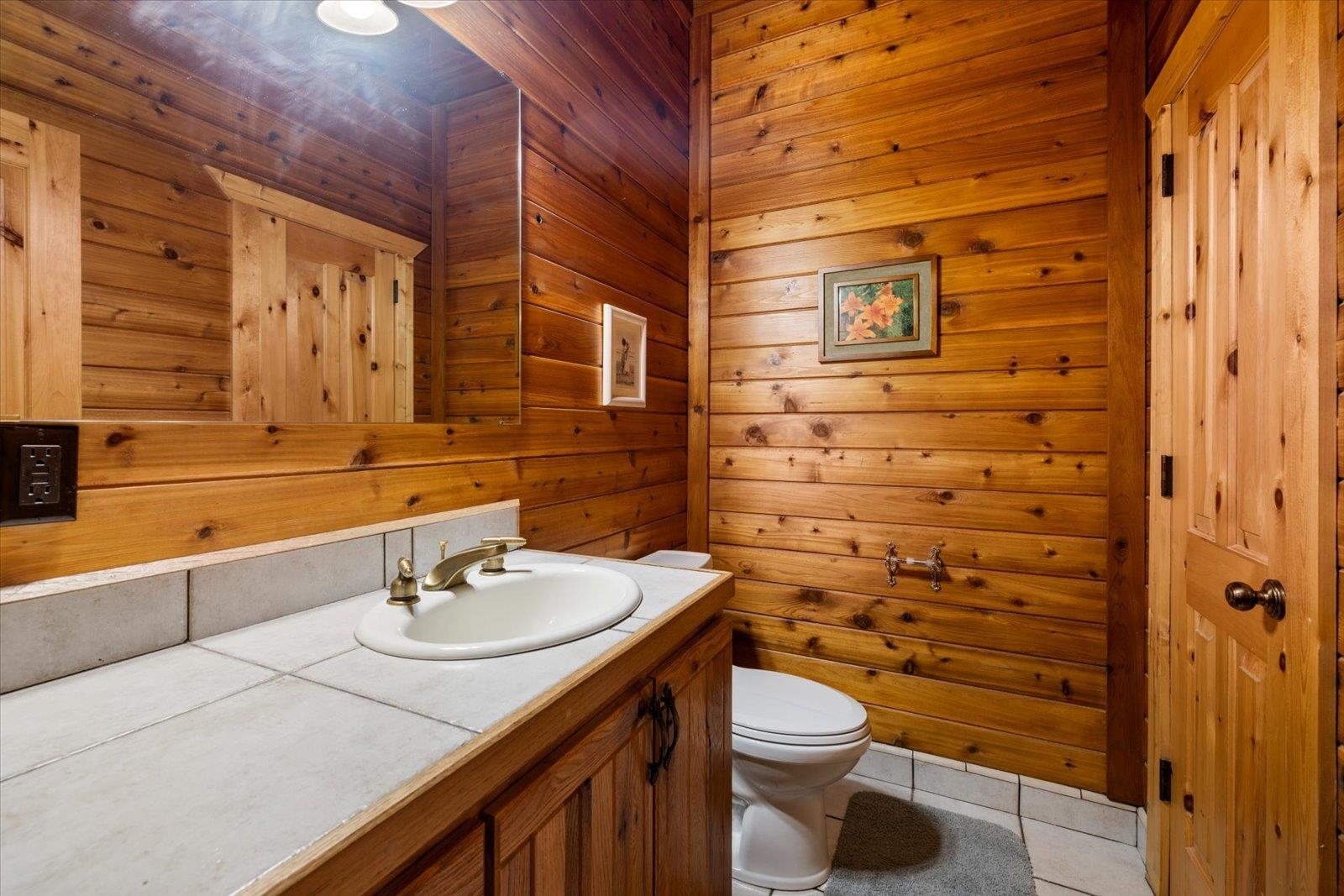 3581 County Line Road Sturgeon Lake, MN 55783 - Photo 56 of 85 Bathroom featuring wooden walls, light tile patterned flooring, and vanity