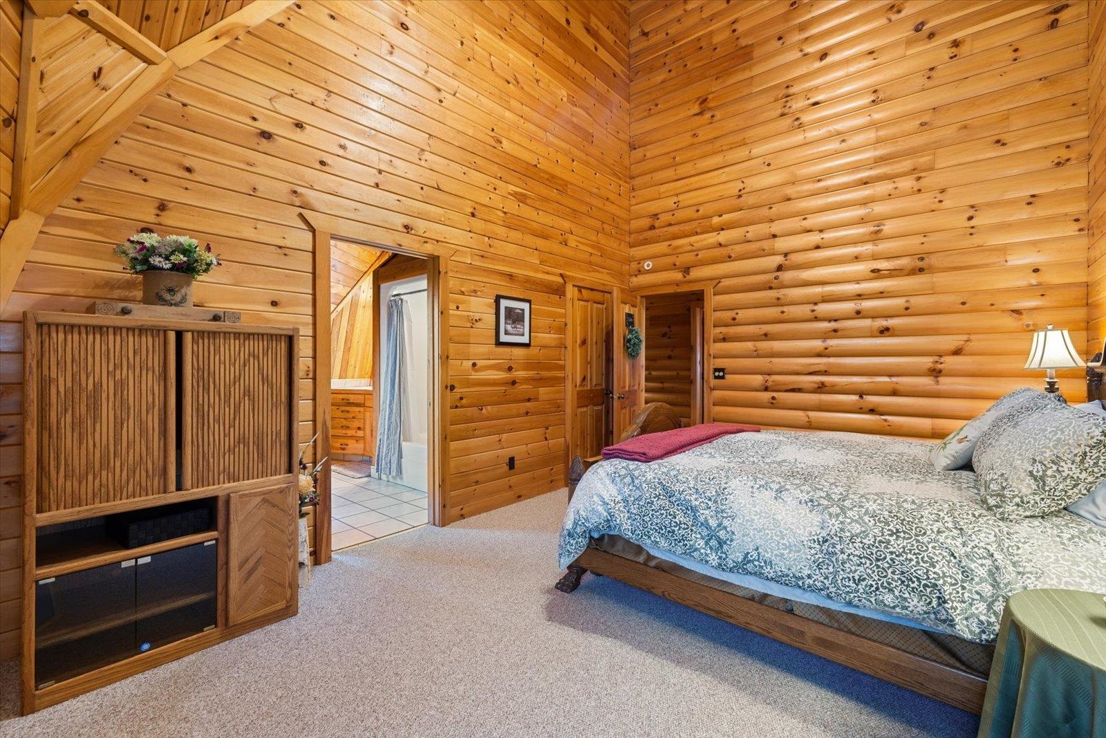3581 County Line Road Sturgeon Lake, MN 55783 - Photo 58 of 85 Carpeted bedroom featuring a towering ceiling and wooden walls