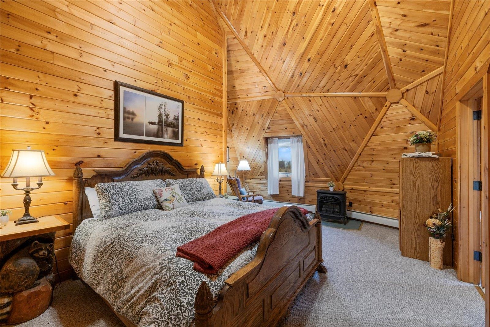 3581 County Line Road Sturgeon Lake, MN 55783 - Photo 68 of 85 Carpeted bedroom with wooden walls, baseboard heating, a wood stove, lofted ceiling, and wood ceiling