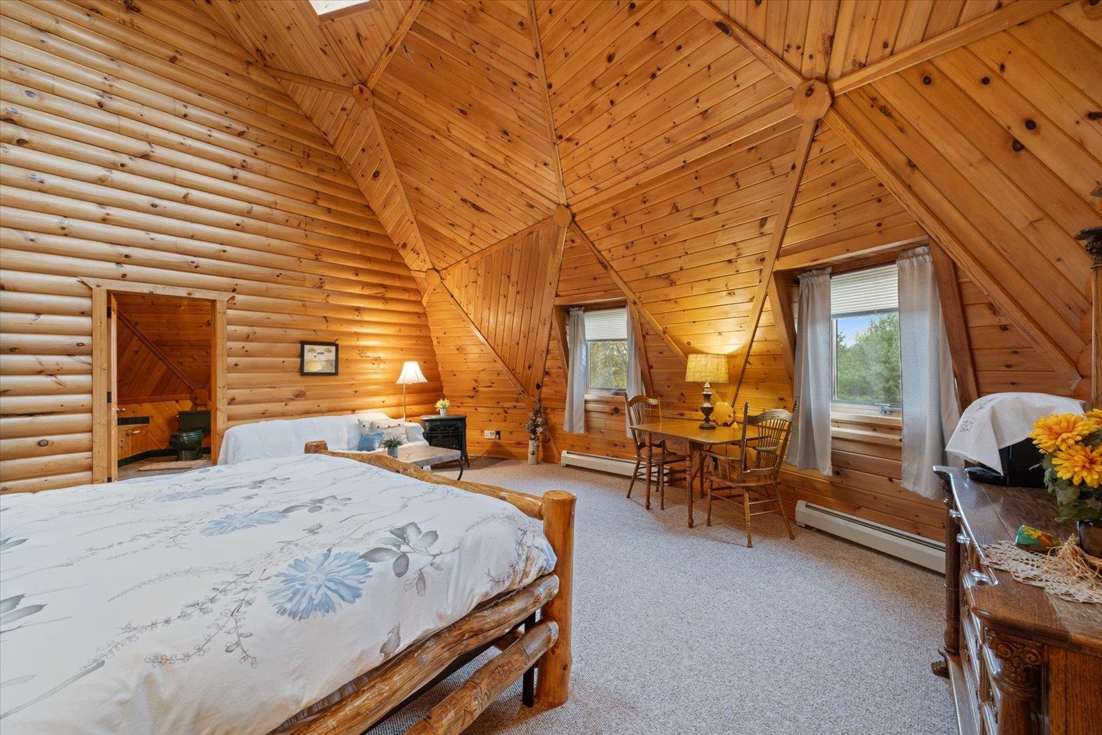 3581 County Line Road Sturgeon Lake, MN 55783 - Photo 71 of 85 Carpeted bedroom featuring a baseboard radiator, high vaulted ceiling, and rustic walls