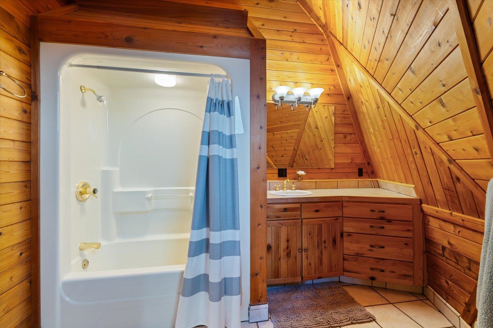 3581 County Line Road Sturgeon Lake, MN 55783 - Photo 73 of 85 Bathroom with wood walls, shower / tub combo with curtain, light tile patterned floors, vanity, and wooden ceiling